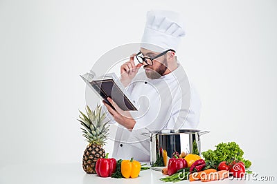 Chef cook in glasses reading recipe book Stock Photo