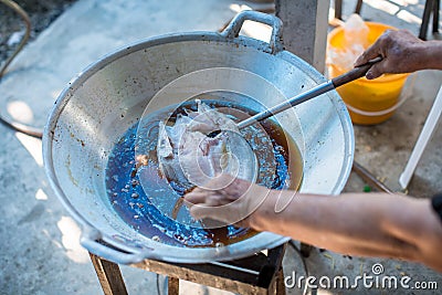 Chef cooking deep-fried fish in the big pan to Chinese banquet food preparation. fat from trans-fat concept. disease from choleste Stock Photo