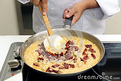 Chef cooking risotto with dried tomato Stock Photo