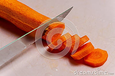 The chef cuts a carrot with a knife Stock Photo