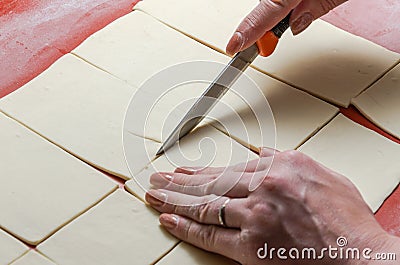 The chef cuts the dough with a knife Stock Photo