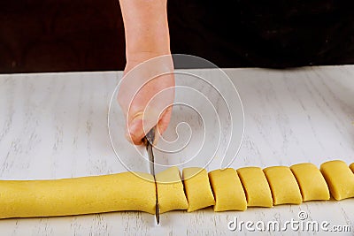 Chef cuts dough with a knife in equal portion for cooking biscuits Stock Photo