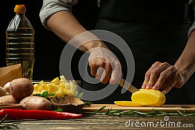 The chef cuts potatoes for cooking. Fat and tasty food. Fast food Stock Photo