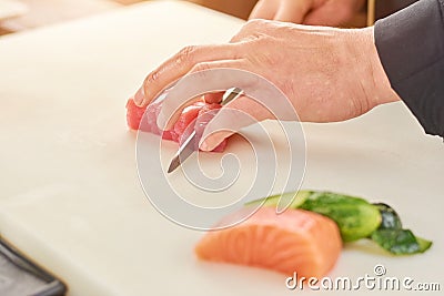 Chef cutting fresh tuna in small pieces. Stock Photo