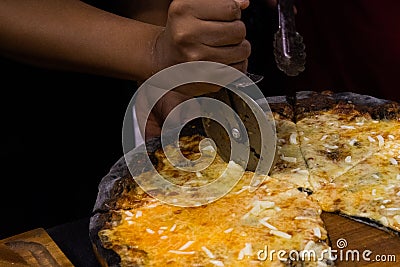 Chef cutting freshly baked pizza, prepared pizza homemade Stock Photo