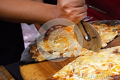 Chef cutting freshly baked pizza, prepared pizza homemade Stock Photo
