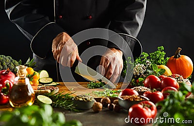 Chef dicing fresh herbs with a kitchen knife Stock Photo