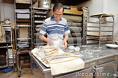 Chef forming dough in order to prepare bread Editorial Stock Photo