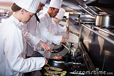 Chef frying fish in a frying pan Stock Photo