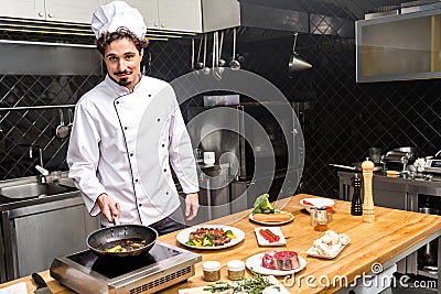 chef frying vegetables and looking Stock Photo