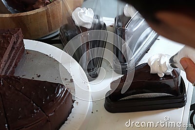 Chef garnish chocolate cake with cream Stock Photo