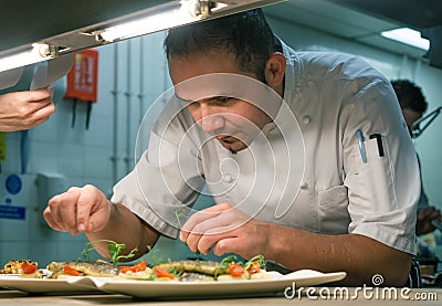 Chef Garnishing Food in Kitchen Stock Photo