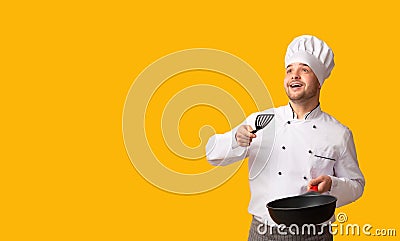 Chef Guy Holding Pan Throwing Invisible Food Standing, Studio Shot Stock Photo