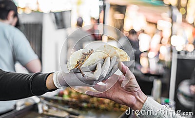 Chef handing a taco to a foodie at a street food market Stock Photo