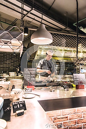 A chef in his open space kitchen in a restaurant in a hotel in Hong Kong Editorial Stock Photo