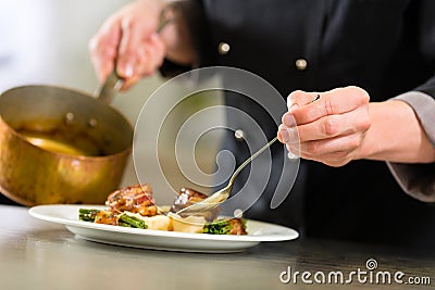 Chef in hotel or restaurant kitchen cooking Stock Photo