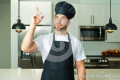 Chef on kitchen. Professional chef man in uniform on kitchen. Bearded chef, cook or baker. Male chef over kitchen Stock Photo