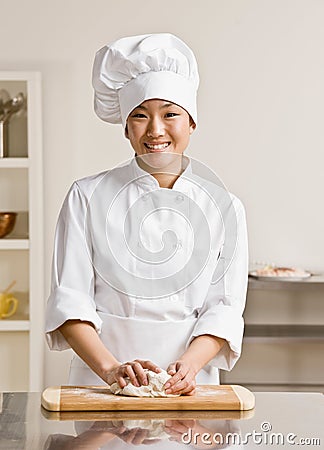 Chef kneading dough in commercial kitchen Stock Photo