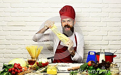 Chef makes dough. Cook with excited face in burgundy uniform Stock Photo