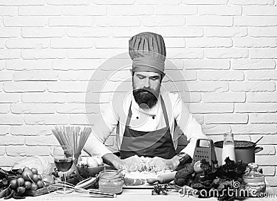 Chef makes dough. Cook with serious face in burgundy uniform Stock Photo