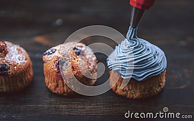 Chef making blueberry cupcakes with cream Stock Photo