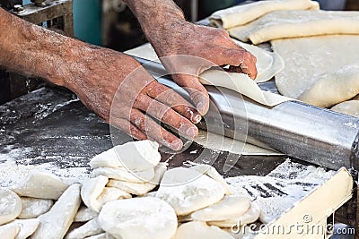 Chef making dough pastry sheeter at bakery Baker forming shaping dough rolled pastry metal work table closeup hands process of pre Stock Photo