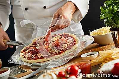 Chef making a prosciutto ham Italian pizza Stock Photo