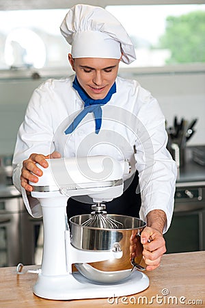 Chef operating electric egg beater Stock Photo