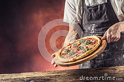 Chef and pizza. Chef offering pizza in hotel or restaurant Stock Photo