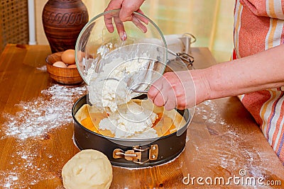 Chef pours batter into pan to prepare apricot cheesecake Stock Photo
