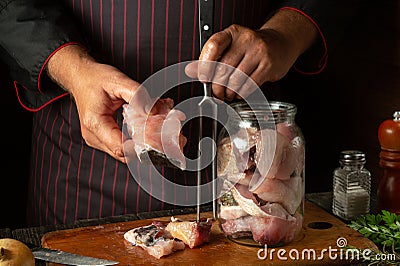 The chef prepares fresh bighead carp fish. Getting ready to cook or salt a fish dish. Working environment in a restaurant kitchen Stock Photo