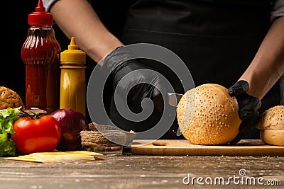 Chef prepares fresh sesame buns for burger cooking, with ingredients on the background, restaurant business, fast food, tasty food Stock Photo