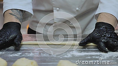 The chef is preparing the dough, the cook is working with the dough in the kitchen, the chefs are sculpting the dough Stock Photo