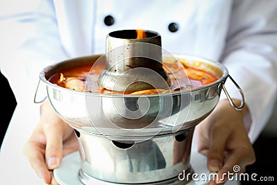 Chef proudly presenting Tom yum goong, famous Thai spicy food Stock Photo