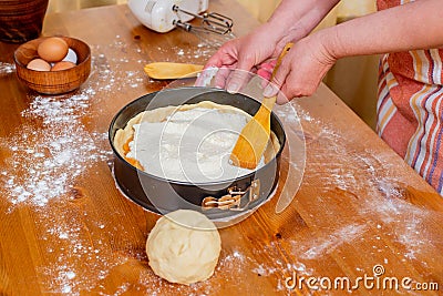 Chef puts cottage cheese in a mold to prepare apricot cheesecake Stock Photo
