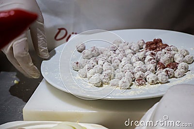 Chef putting raw meatballs in a plate with flour Stock Photo