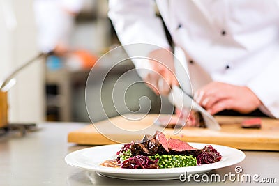 Chef in restaurant kitchen preparing food Stock Photo