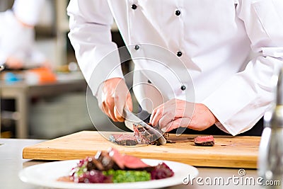 Chef in restaurant kitchen preparing food Stock Photo