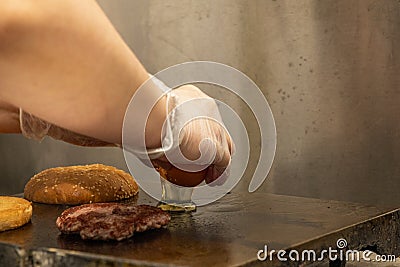 Chef's hands cracking an egg to fry it on the griddle of a restaurant next Stock Photo