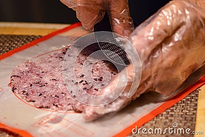 Chef`s hands press sushi rice on a mat Stock Photo