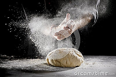 Chef scattering flour while kneading dough Stock Photo