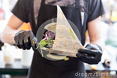 Chef serving organic vegetarian fish burger at international urban street food festival. Stock Photo