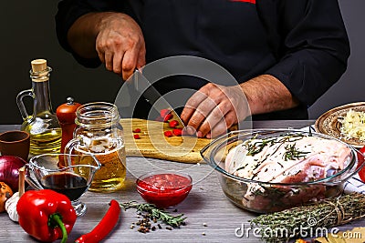 Chef sharp chili on wooden table background. Bavarian pork knuckle cooking. Food homemade recipe concept Stock Photo