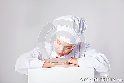 Chef Sign. Woman cook / baker looking over paper sign billboard. Surprised and funny expression woman on white background Stock Photo