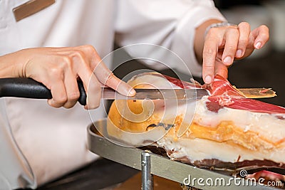 Chef slices serrano ham. Jamon Serrano. Typical Spanish delicate Stock Photo