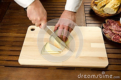 Chef slicing cheese, hands detail Stock Photo