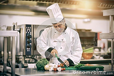 Chef slicing tomatoes in professional kitchen Stock Photo