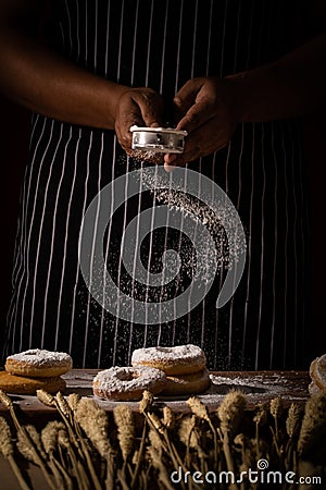 Chef spreading flour on bakery prepare for baking. Cook showing Stock Photo