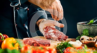 Chef sprinkling coarse salt on a ribeye steak Stock Photo