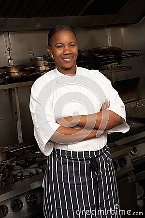 Chef Standing Next To Cooker In Kitchen Stock Photo